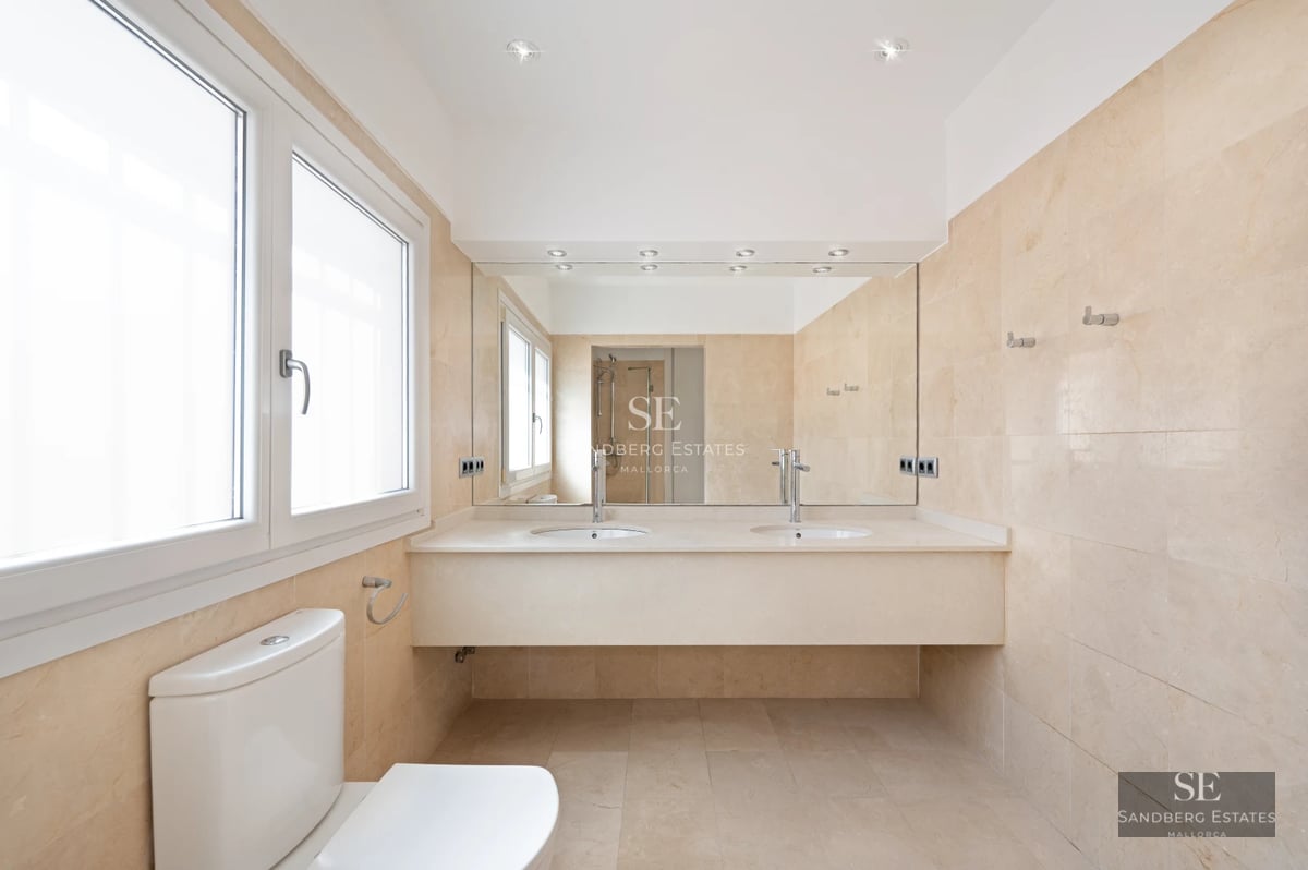 Modern balcony with glass railing, panoramic sea views, plants, and stylish outdoor furniture. Soft ambient lighting.