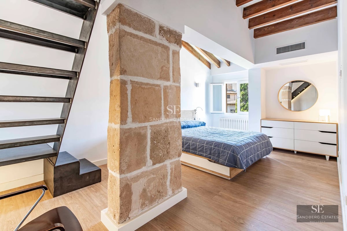 View of infinity pool with vanishing edge, surrounded by greenery and lounge chairs. Modern architecture with large windows and natural light.
