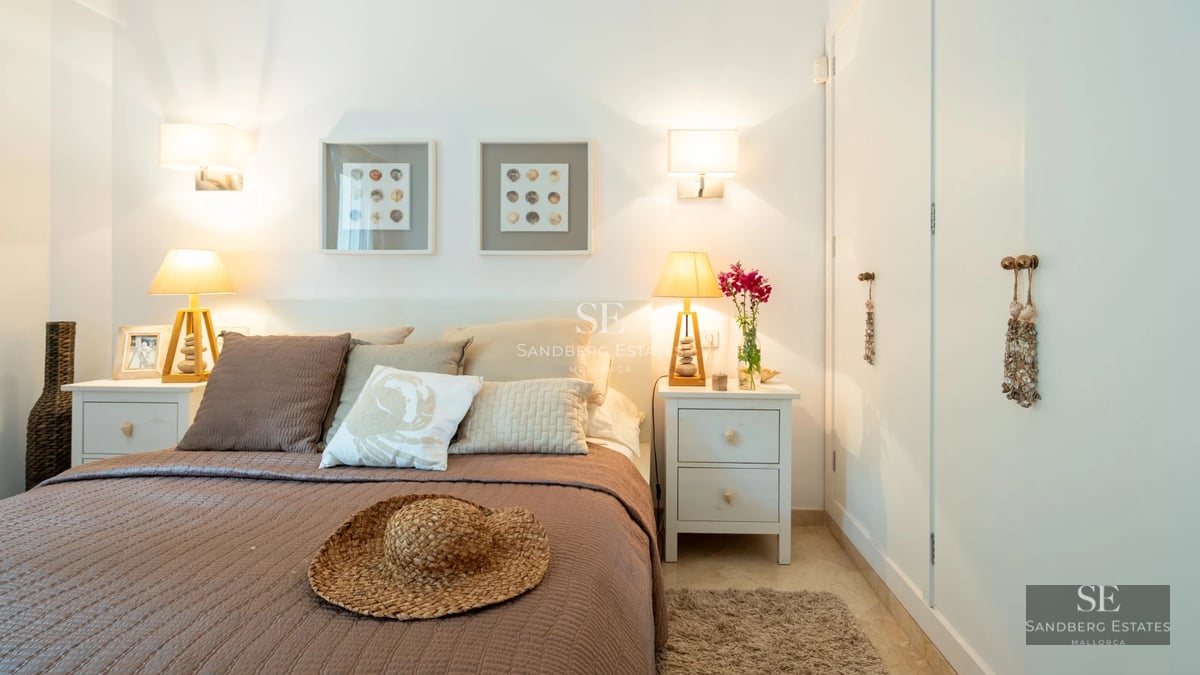 View of a luxurious pool with lounge chairs and lush vegetation. Modern architecture with large windows and minimalist design.