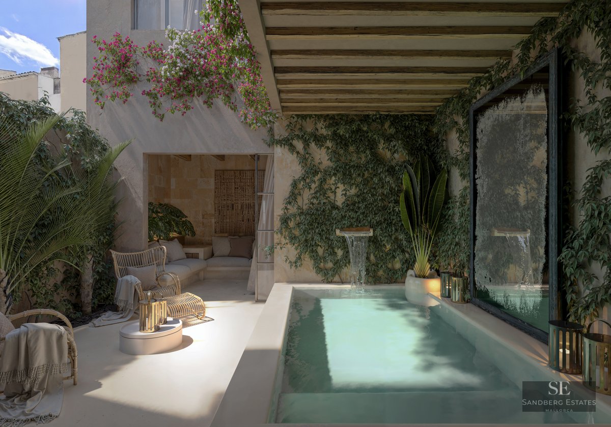 Private plunge pool with waterfall feature surrounded by ivy walls, bougainvillea, and wicker seating under a pergola.