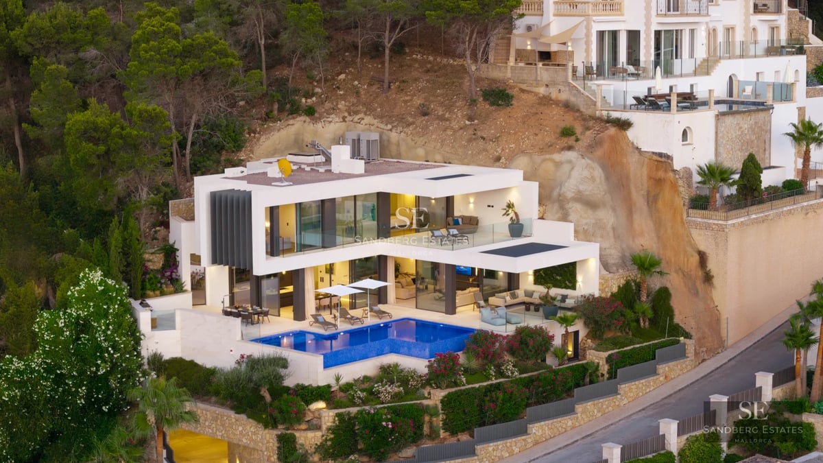 Exterior view of a modern villa with a pool, large windows, and minimalist design. Lush garden.