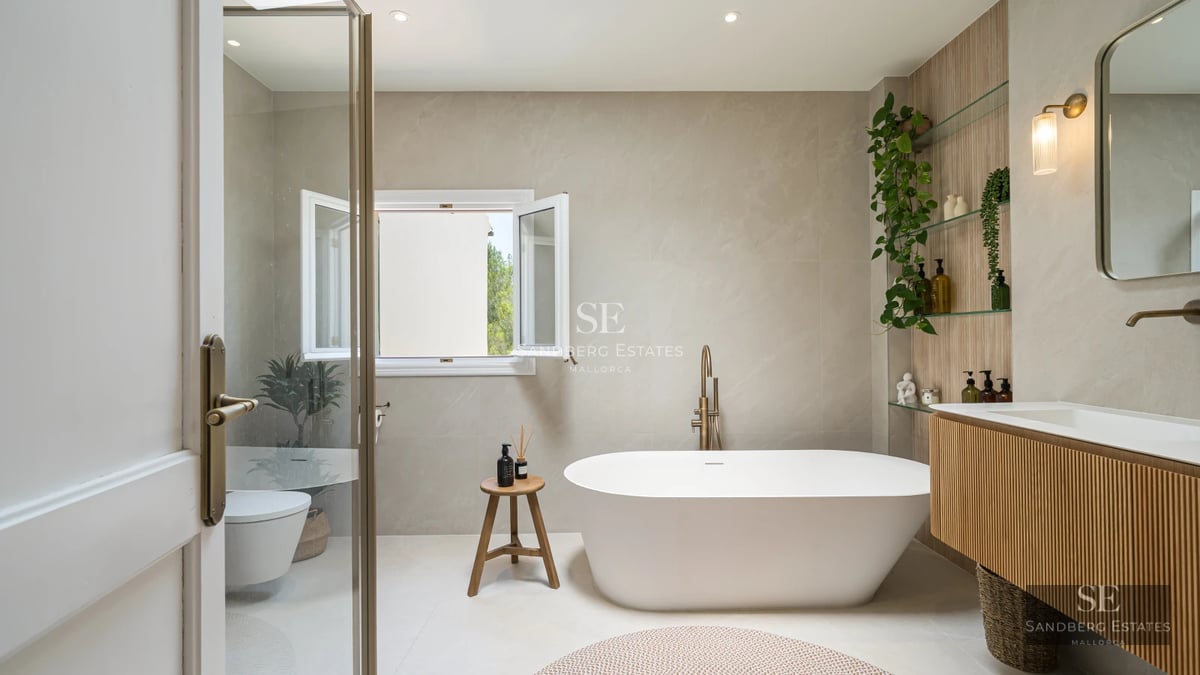 Spacious balcony with sea view. Modern outdoor sofa, wooden floor, glass railing, clear blue sky. Bright and spacious.