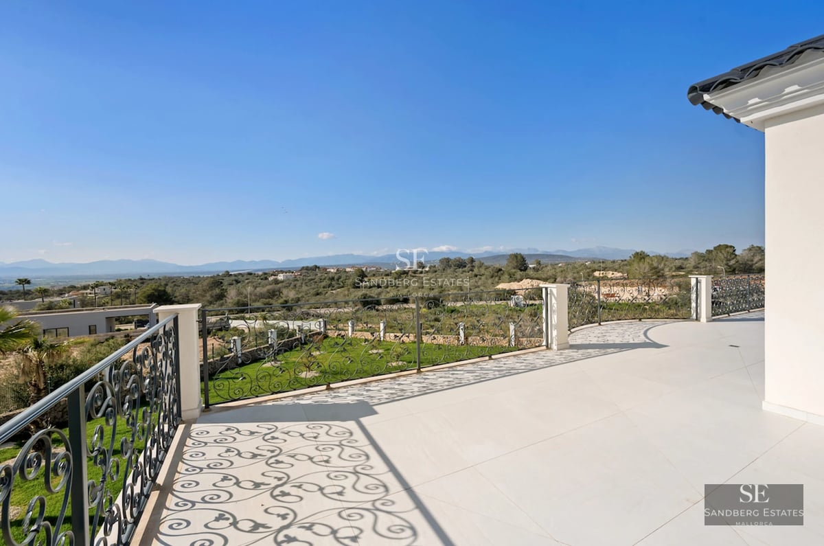 Spacious garden with a pool, sun loungers, and seating area. Modern architecture with large windows. Lush vegetation.