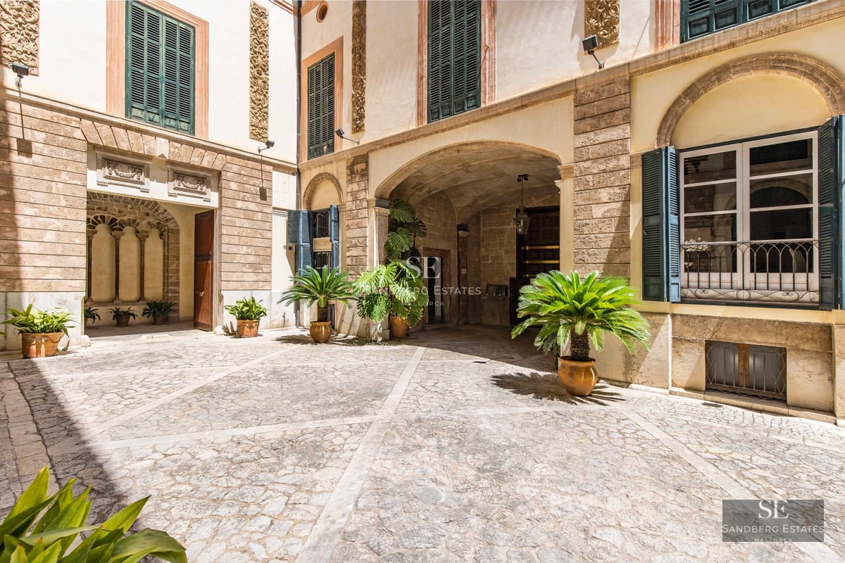 Modern terrace with ocean view. Infinity pool, designer furniture and glass railing. Clear blue sky and natural surroundings.