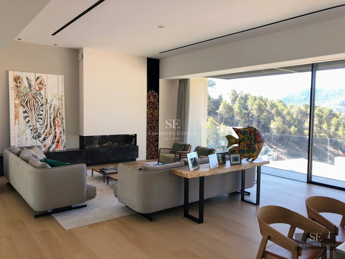 View of an infinity pool with sun loungers, umbrellas, and lawn. Modern and relaxing design with panoramic views.