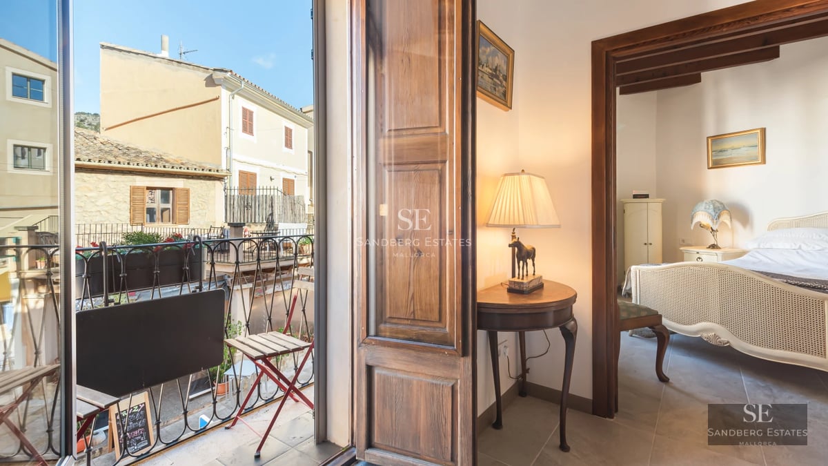 Pool view with light tiles, surrounded by greenery and stone walls. Natural lighting. Modern and elegant design.