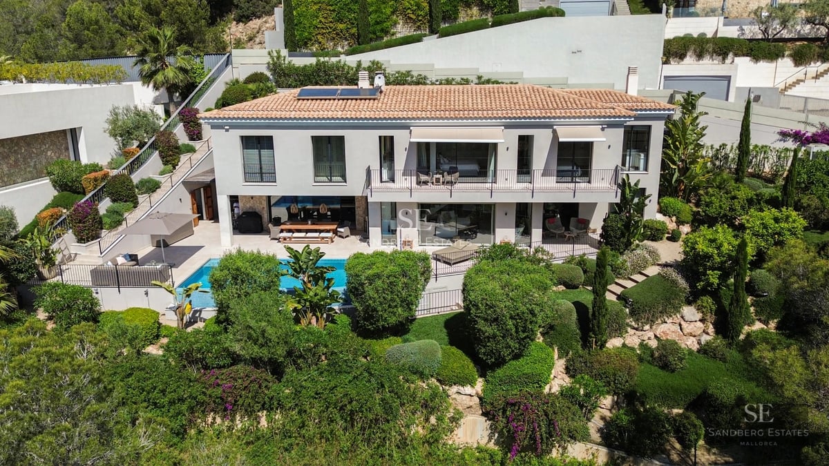 Exterior view of a modern villa with infinity pool. Minimalist design, large windows and lush natural surroundings.