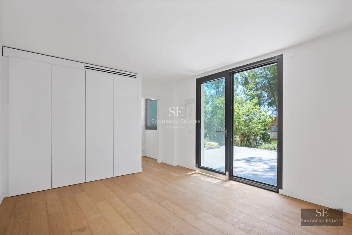 Wide view of a modern villa with a reflecting pool. Minimalist design with large windows and a spacious terrace.