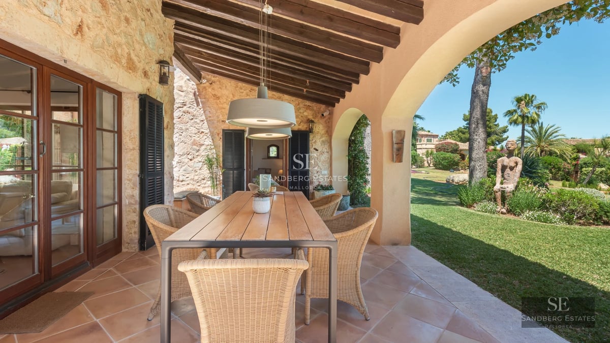 View of a luxurious villa with infinity pool, spacious terraces, and modern design. Lush gardens and panoramic views.