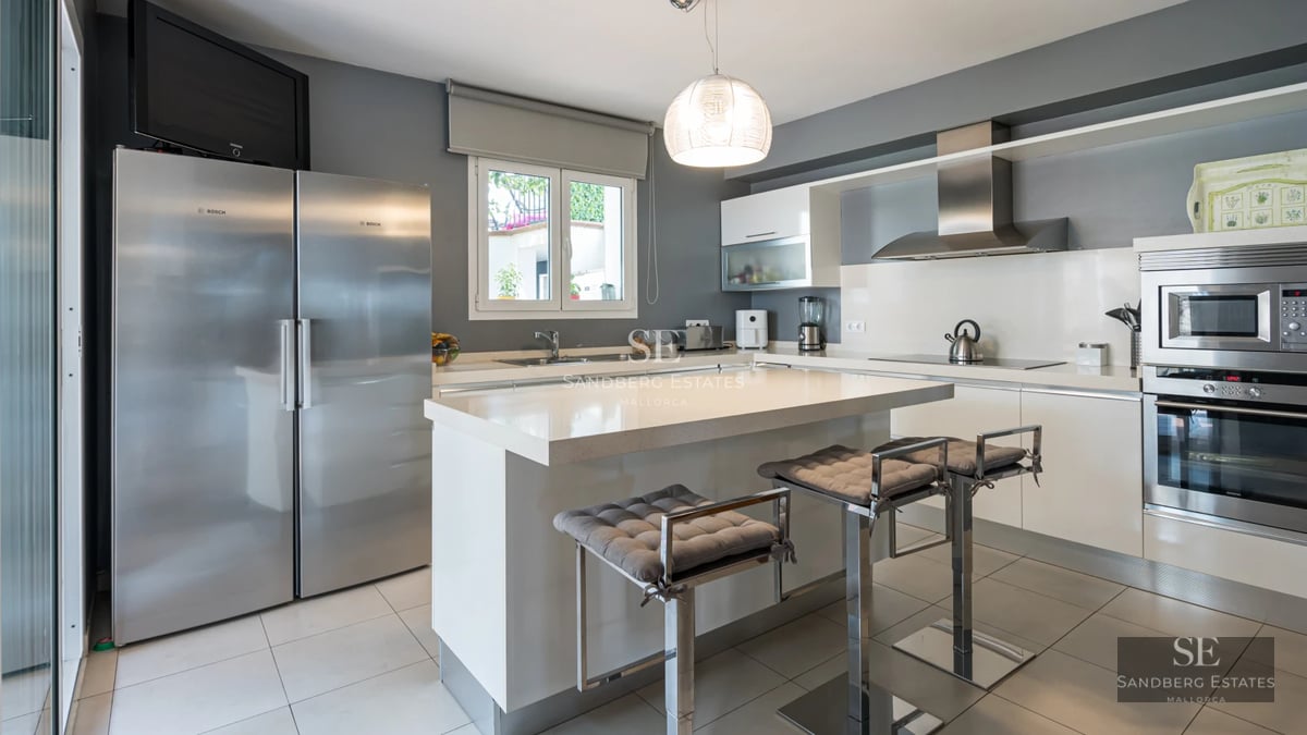 Panoramic view of modern villa with infinity pool, sun loungers, and lush vegetation. Minimalist architecture and landscaping design.