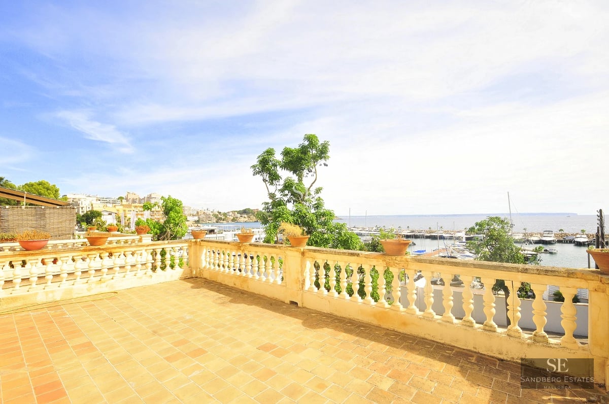 Spacious balcony with panoramic sea views. Modern design, glass railing, and elegant outdoor furniture.