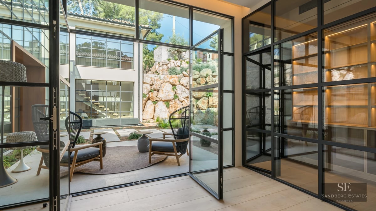 Pool view with terrace and modern armchairs, surrounded by lush greenery. Minimalist design, soft lighting and relaxing atmosphere.