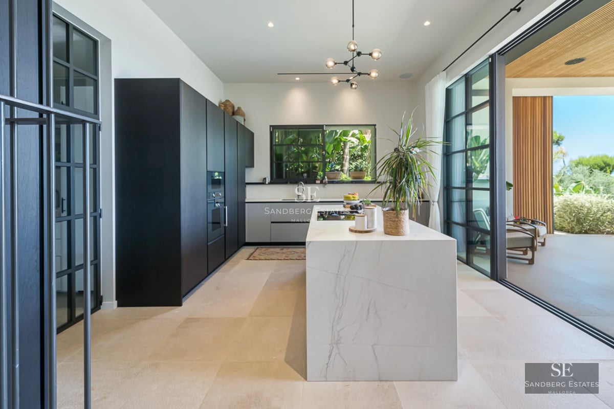 Salon spacieux avec baies vitrées offrant une vue sur la mer. Design moderne, lumière naturelle, parquet et mobilier élégant. Vues panoramiques.