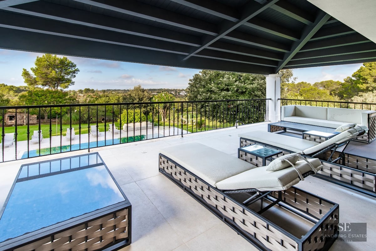 View of infinity pool and garden of a modern villa with stylish outdoor furniture and lush landscaping design.