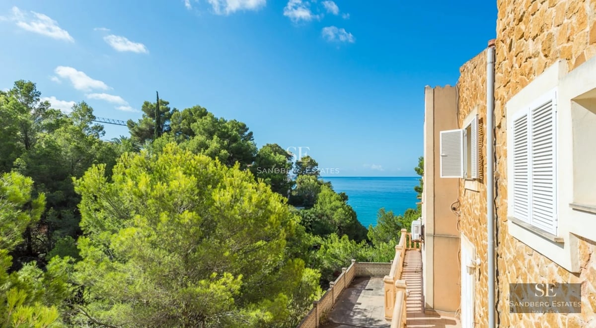 Spacious living room with large windows, reflecting pool and lush garden. Modern design, luxurious finishes and abundant natural light.