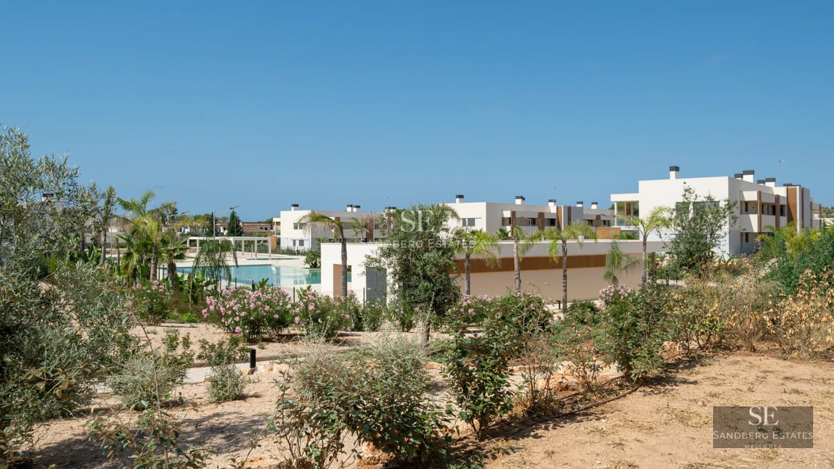 Aerial view of a luxurious modern villa featuring an infinity pool, expansive gardens, and minimalist architectural design.