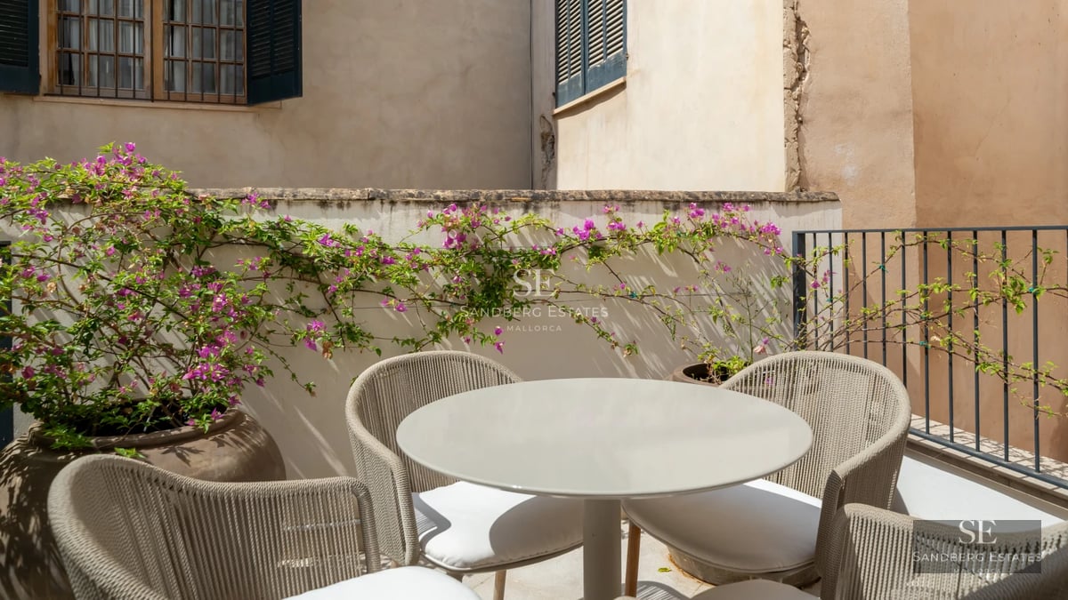 Bright living room with panoramic sea views. Beige sofa, light walls, large window, balcony. Modern and elegant interior design.