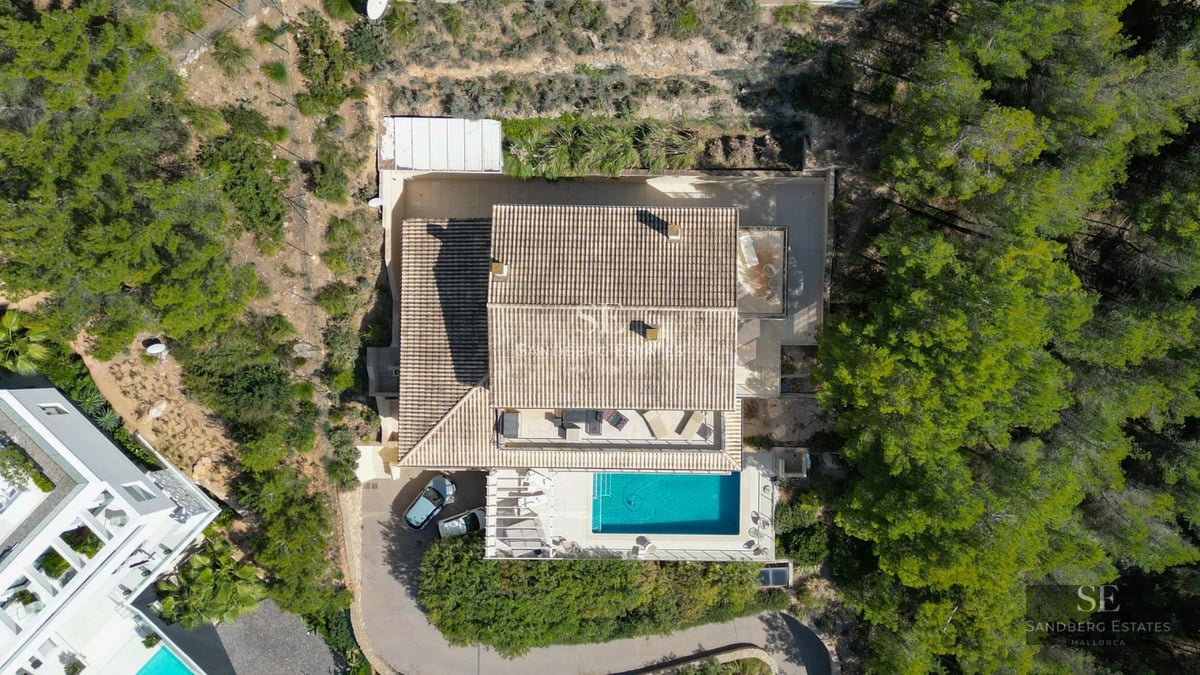 Exterior view of a modern villa featuring a pool, garden, and spacious terraces. Minimalist architecture with large windows and luxurious finishes.