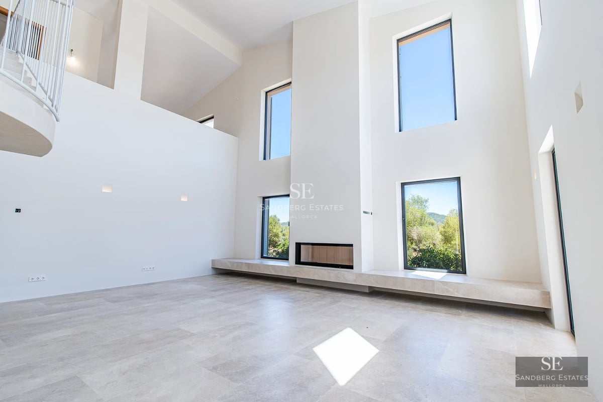 Aerial view of a modern villa featuring an infinity pool, spacious terraces, and lush garden. Contemporary architectural design with clean lines.