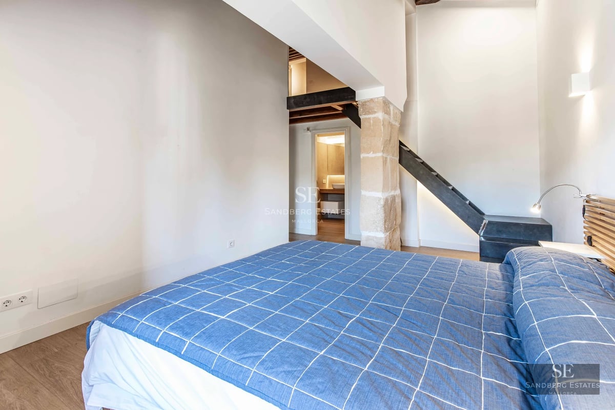 Spacious living room with natural light, modern fireplace, large windows, wood floor, and terrace access. Garden view.