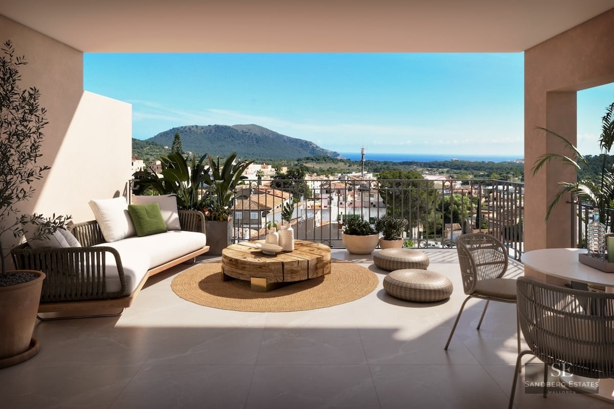 Covered terrace with designer lounge furniture, wooden coffee table, and expansive views of the sea and mountains.