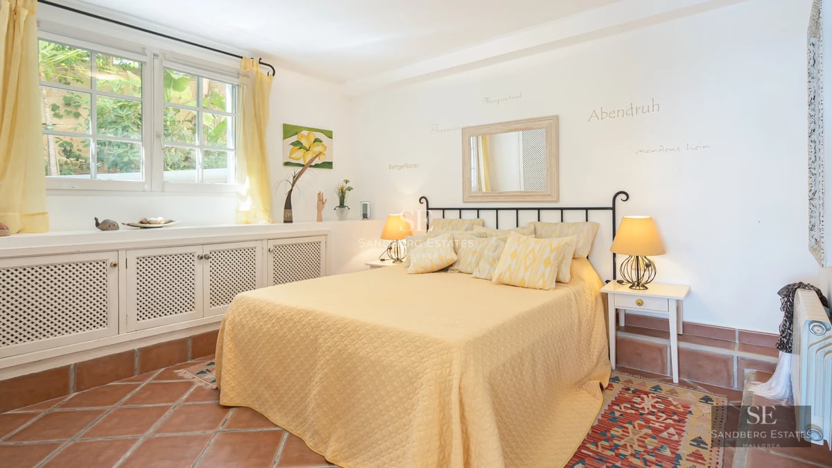 Spacious balcony with ocean views. Modern, minimalist furniture. Wood floors and glass railing. Lush green vegetation.