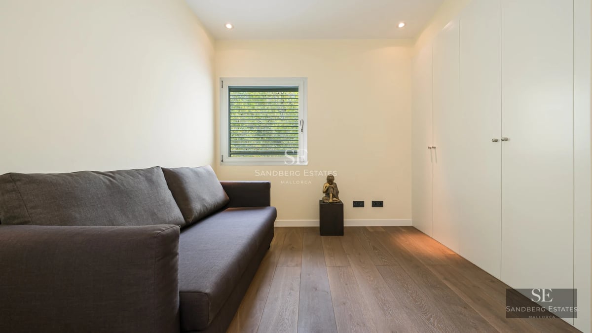 Spacious, bright living room with large windows, light wood floors, and modern furniture. Garden view. Minimalist and elegant design.