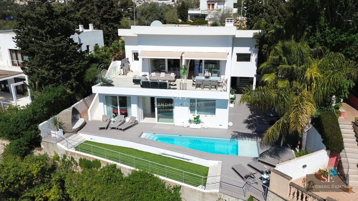 Infinity pool with sea views, modern sun loungers and lush vegetation. Minimalist and elegant design.