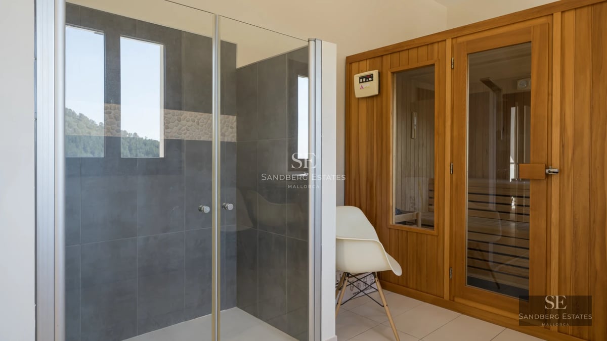 Infinity pool view with glass edge, sun loungers, lush greenery, and modern design. Clear blue sky.