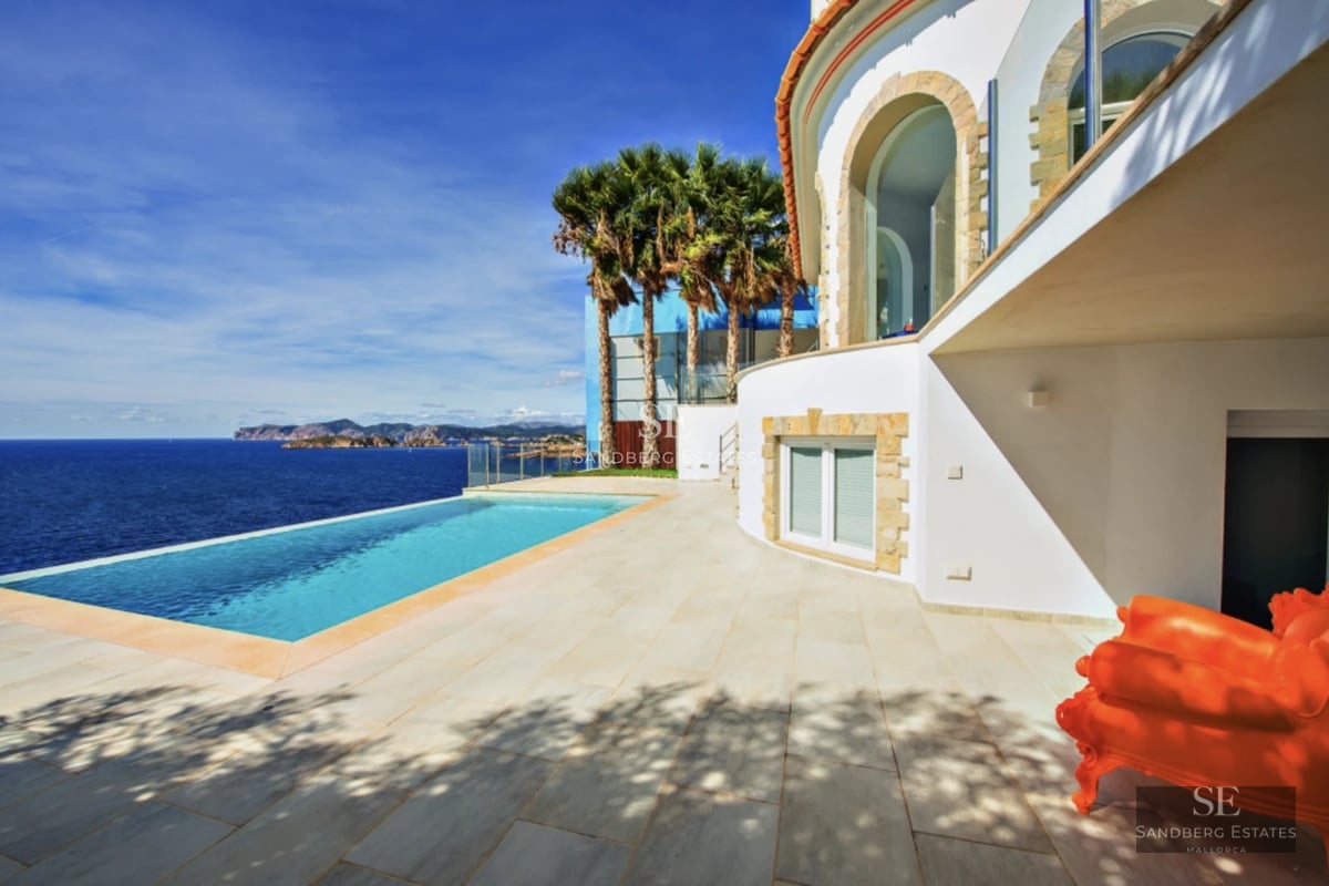 Spacious terrace featuring an infinity pool, panoramic sea views, modern furniture, and minimalist architectural design.