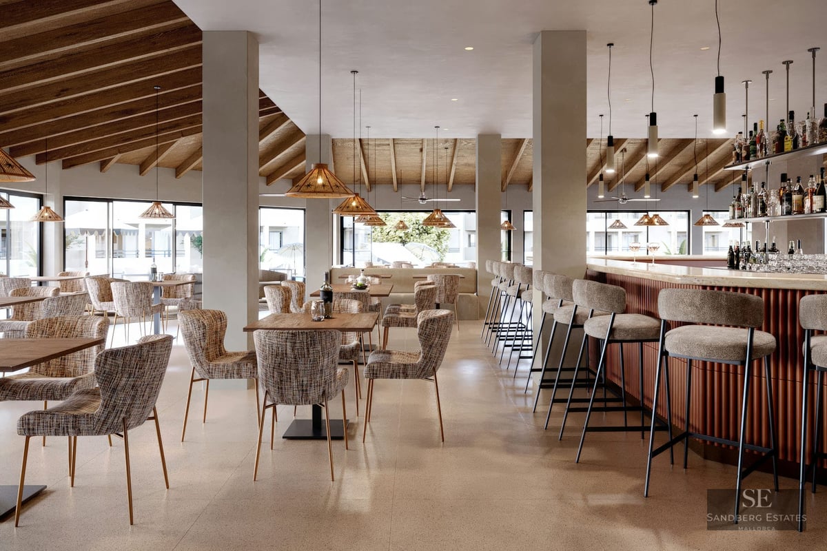 Intérieur d'un salon moderne avec plafonds en bois, suspensions, tables à manger et un bar avec tabourets hauts.