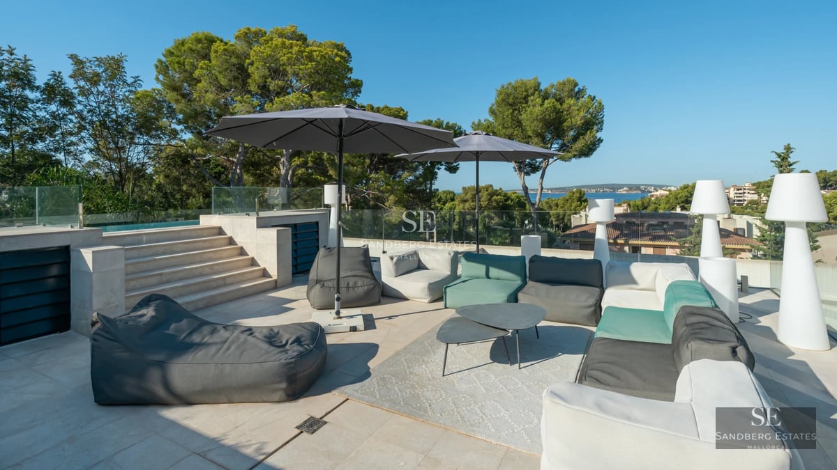 Exterior view of a modern villa with infinity pool. Minimalist architecture, large windows, lush garden and blue sky.