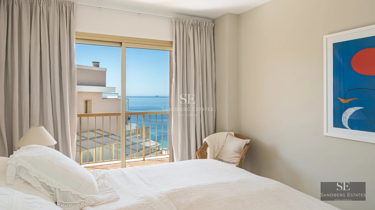 Spacious living room with floor-to-ceiling windows, reflecting pool, light wood floors, and minimalist design. Garden view.