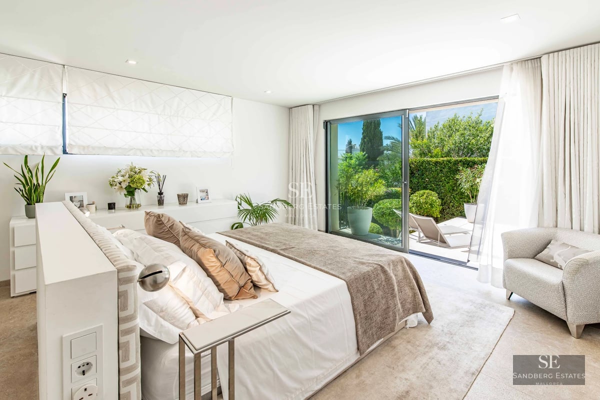 Exterior view of a modern villa featuring an infinity pool, manicured garden, and spacious terraces. Minimalist architecture with large windows.