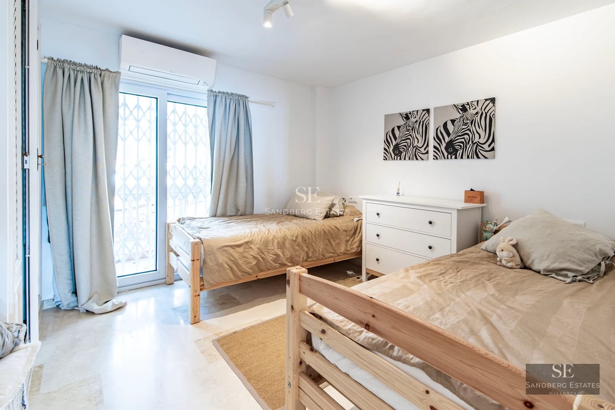 Spacious living room with panoramic windows, light wood flooring, modern fireplace, and minimalist furniture. Abundant natural lighting.