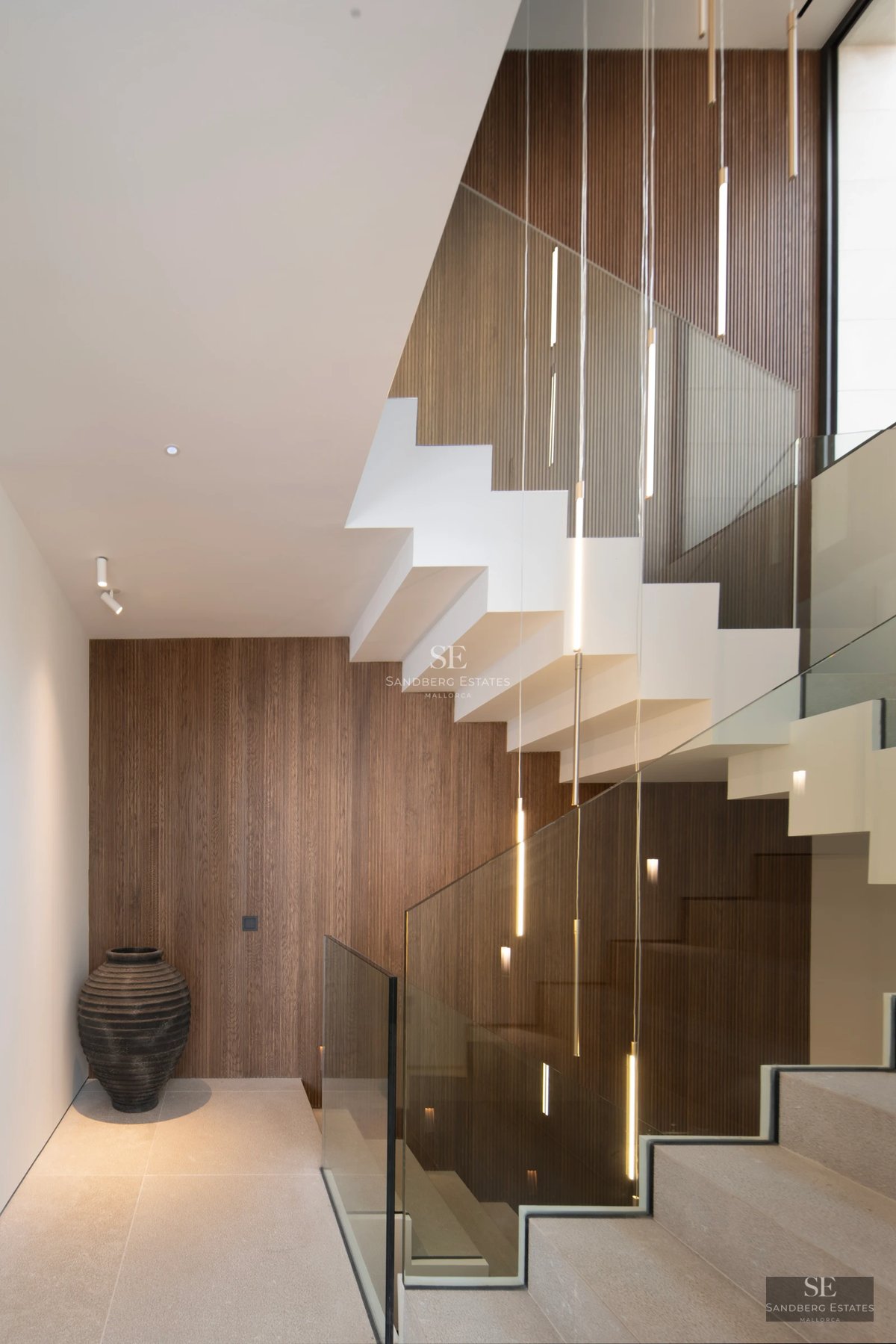 Exterior view of a modern villa featuring a pool, lush garden, and expansive terraces. Minimalist architecture and abundant natural light.