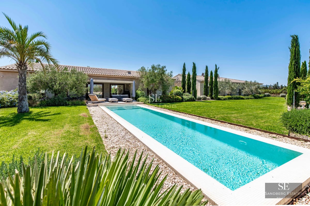 Expansive outdoor area featuring a reflective pool, outdoor living space, minimalist garden, and modern architecture with picture windows.