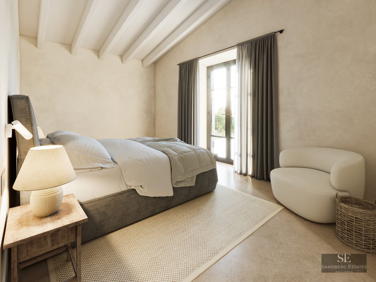 Bright minimalist bedroom with exposed white ceiling beams, a grey bed, white armchair, and glass door to a terrace.