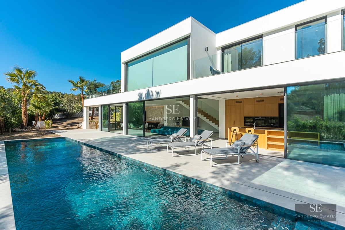 Extérieur d'une villa moderne avec piscine, pelouse et grandes baies vitrées. Design minimaliste aux lignes épurées et lumière naturelle abondante.