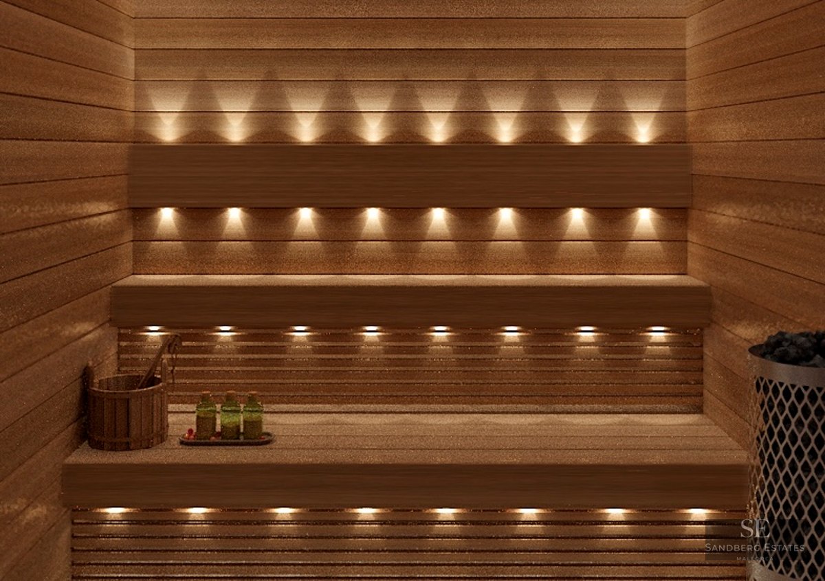 Interior of a wooden sauna with warm integrated lighting, wooden benches, and wellness accessories.