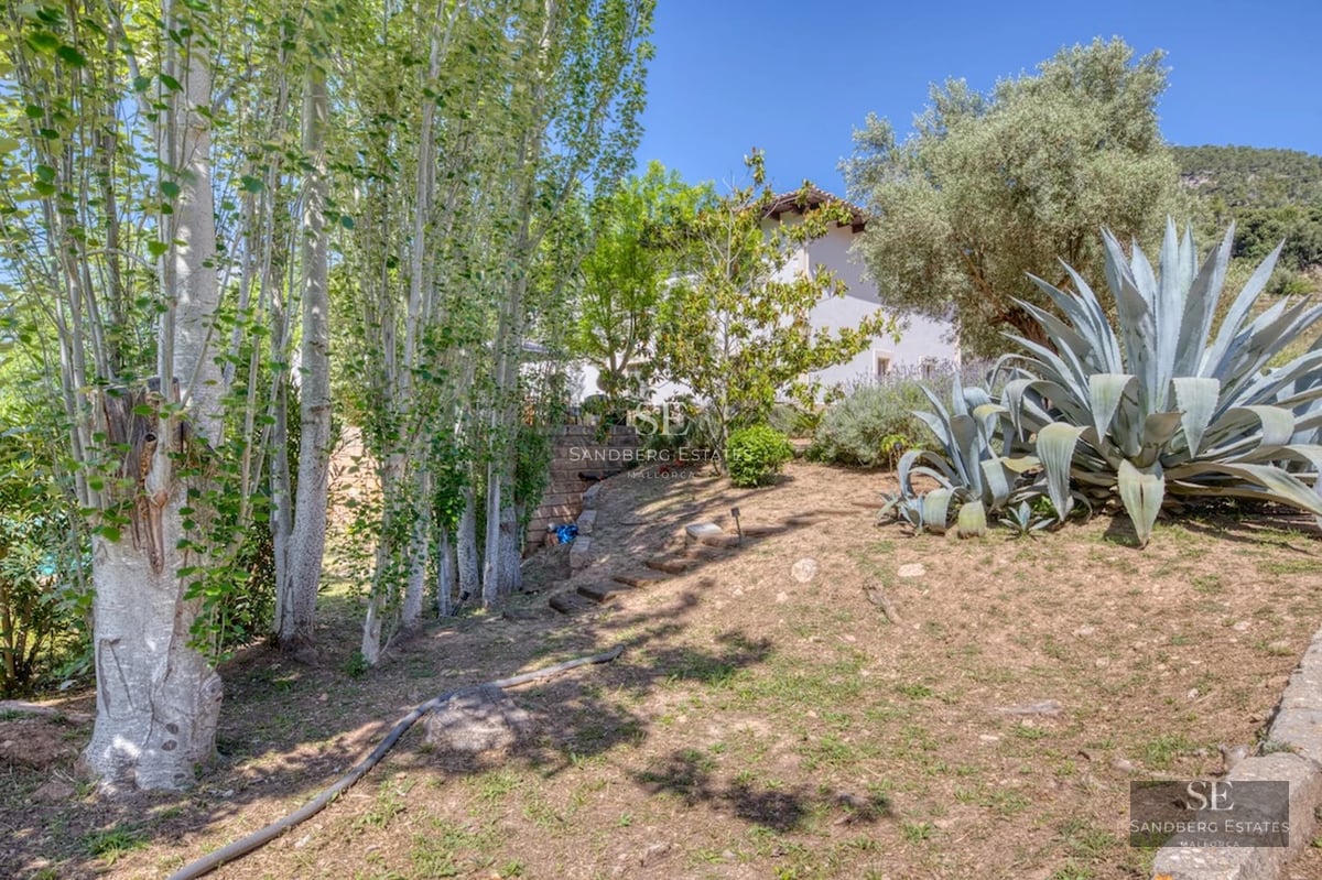 Exterior view of modern villa with infinity pool. Stone facade, large windows, and minimalist design. Blue sky.