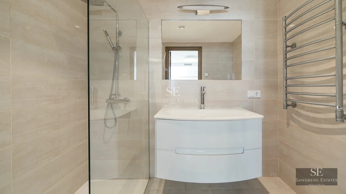 View of terrace with pool, sun loungers, and parasol. Modern facade with large windows. Lush garden with tropical vegetation.