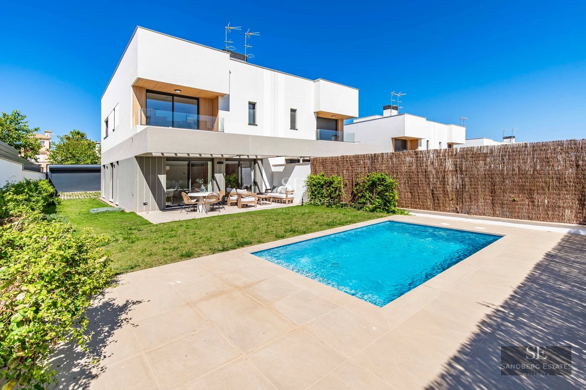 Exterior of a modern villa with an infinity pool, lush garden, and expansive terraces. Minimalist architecture and panoramic views.