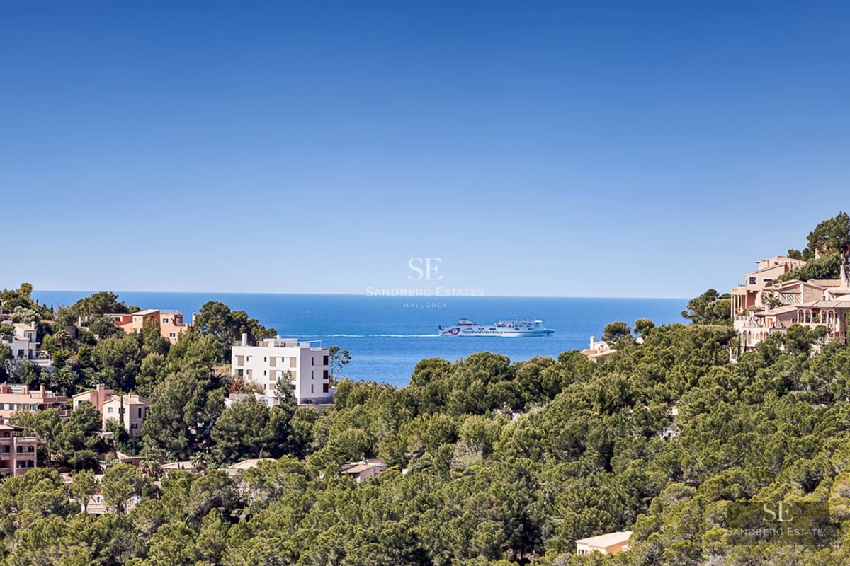 Spacious balcony with panoramic sea view. Modern design with glass railing and elegant furniture. Warm lighting and relaxing atmosphere.