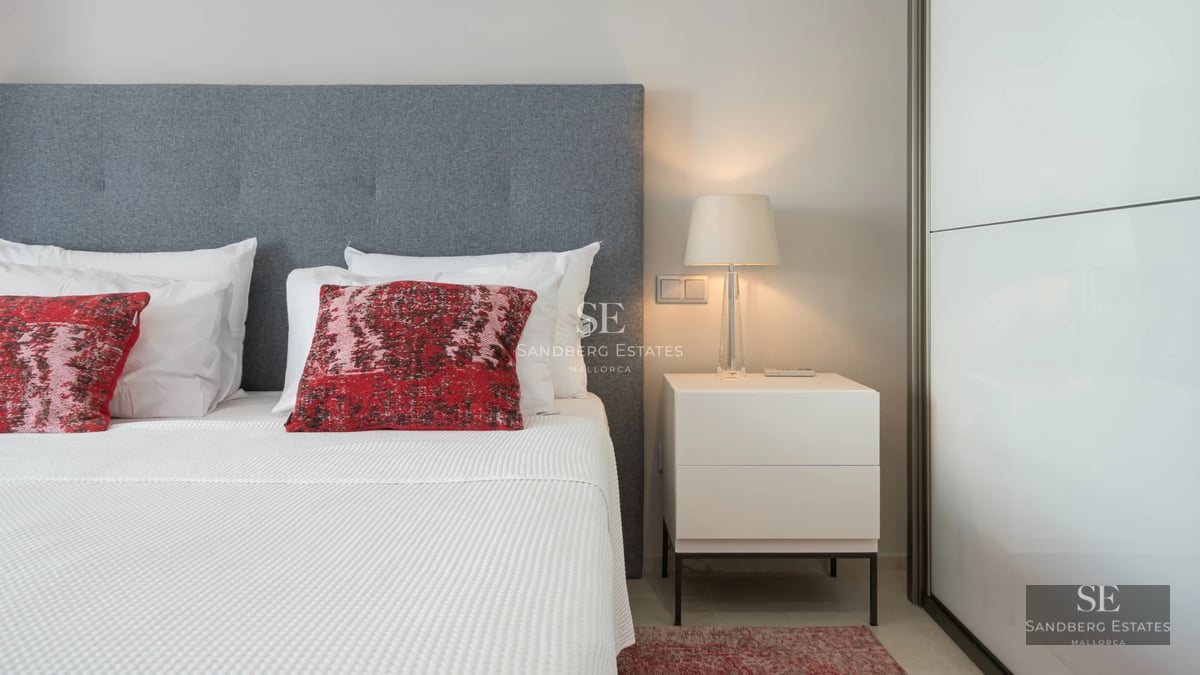 Spacious, bright living room with fireplace, panoramic windows, and minimalist decor. View of the Mediterranean Sea.