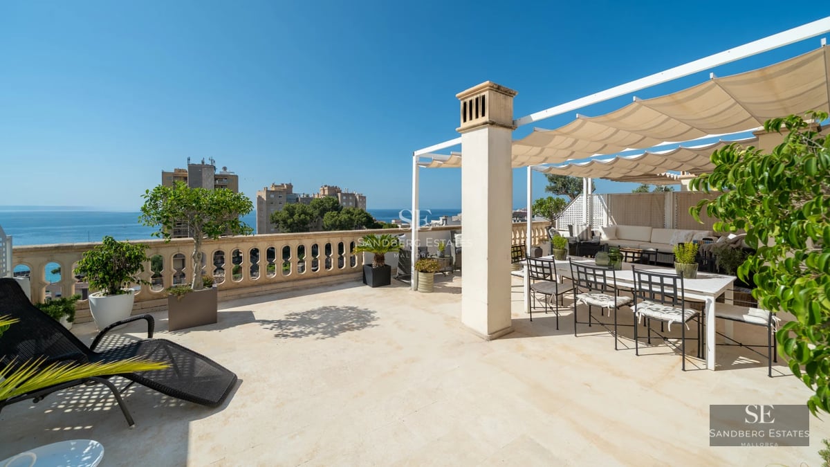View of pool and garden with sun loungers in a modern property. Large windows illuminate the interior. Lush vegetation.