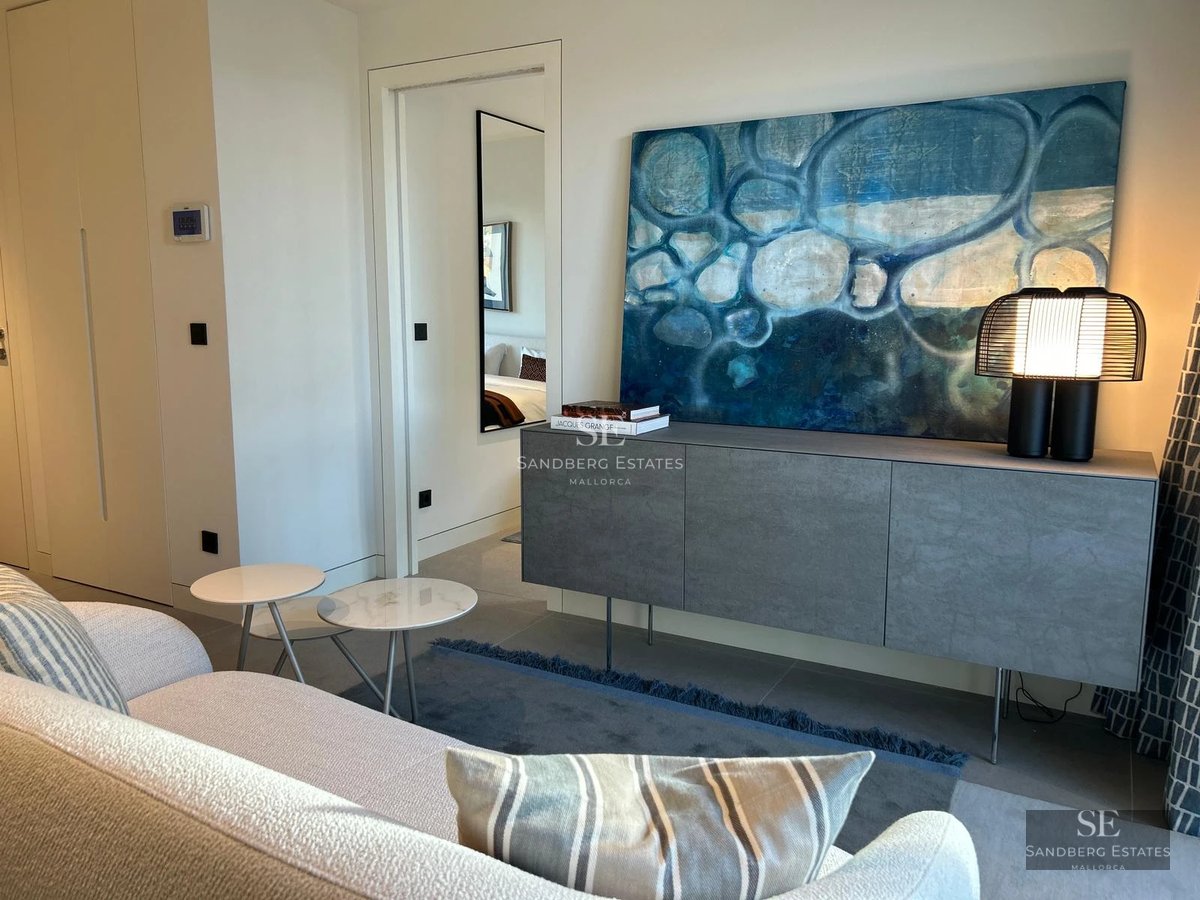 Modern facade with reflecting pool, large windows, minimalist landscaping and ambient lighting.