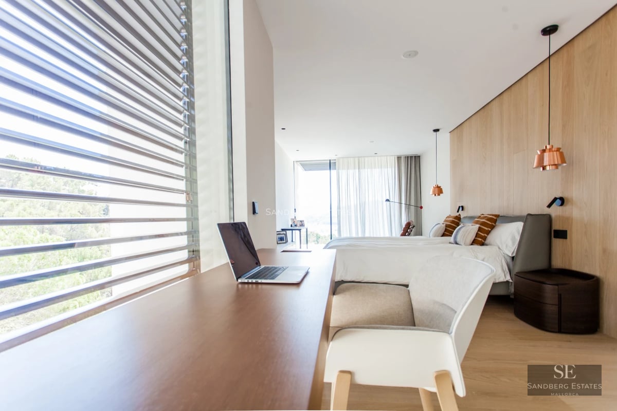 Spacious balcony with sea view. Glass railing, wooden floor, recessed lighting. Modern and elegant design. Relaxing atmosphere.