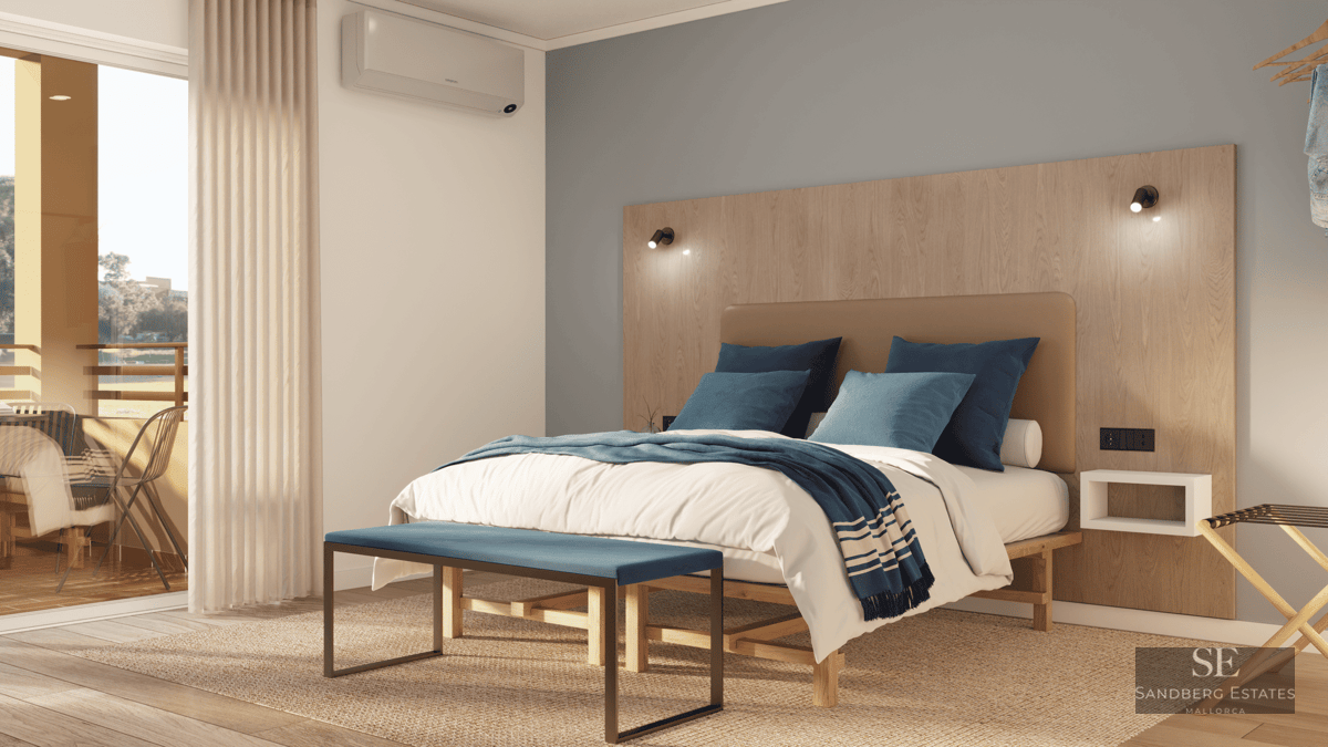 Modern bedroom featuring a wood headboard, blue bedding, a bench, and a sliding glass door leading to a sunlit balcony.