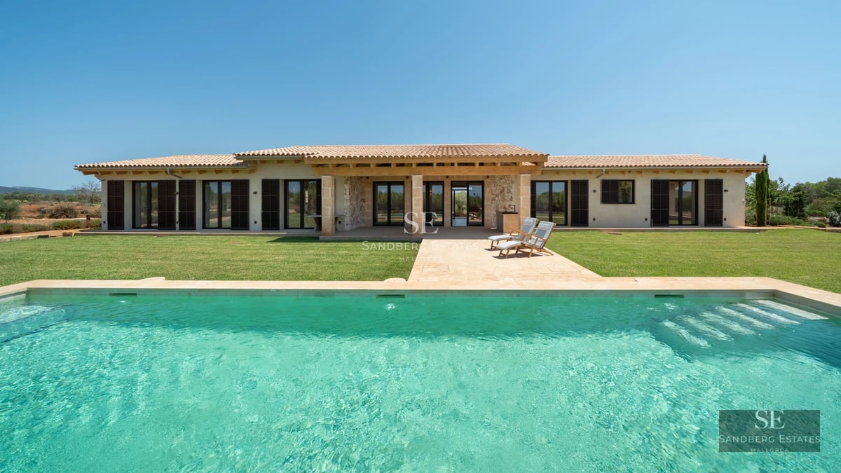 Bright living room with direct access to pool. Large windows, light wood floors and minimalist modern design. Elegant interior.